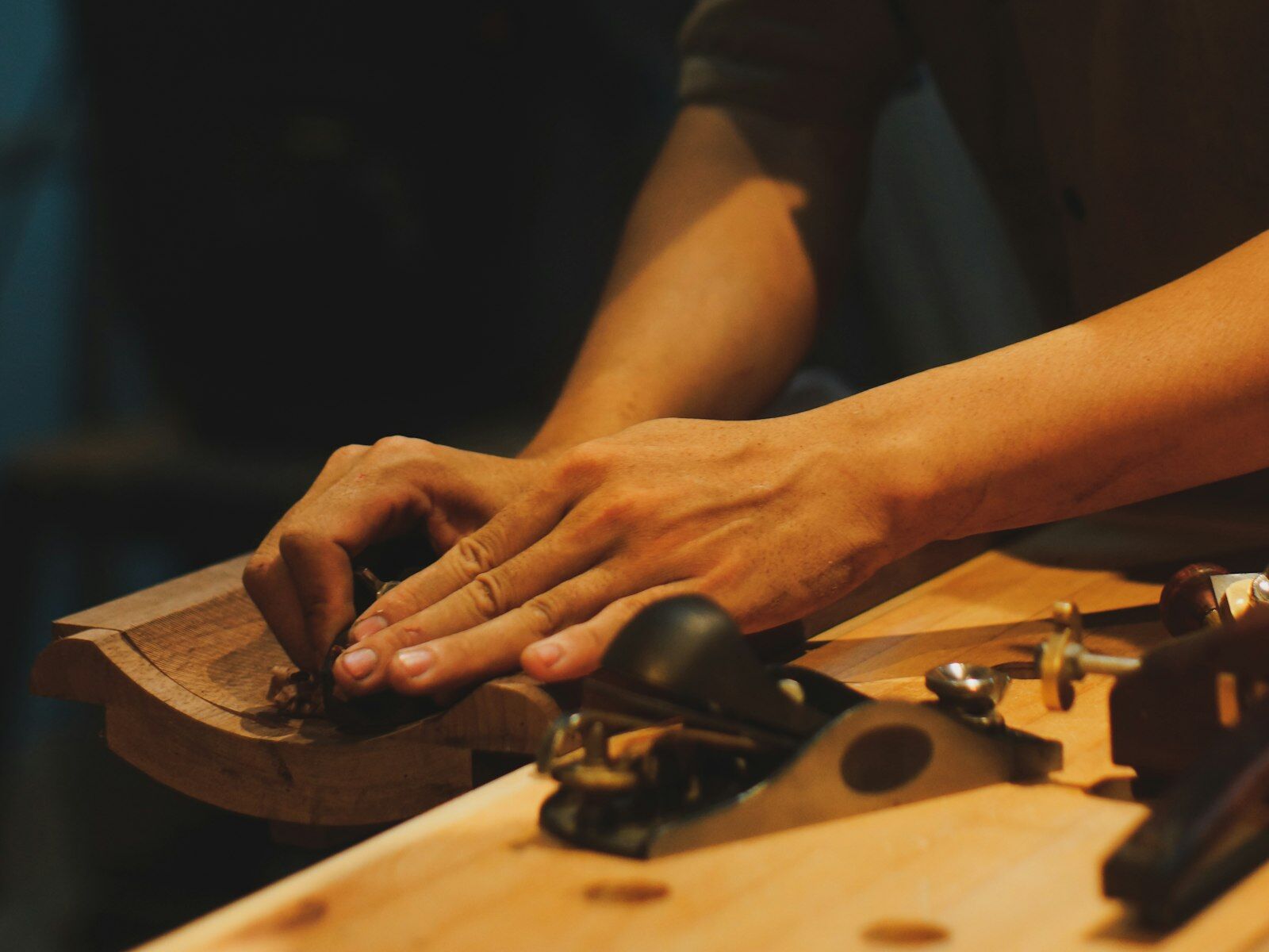 Craftsman planing a board on a workbench