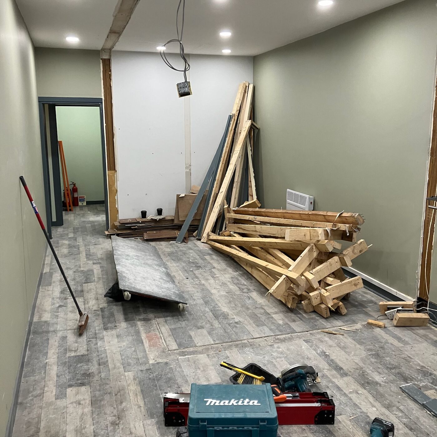 Workshop mid-fit-out: timber stud frame, new opening and offcuts on the floor